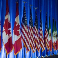 Des drapeaux du Canada, des États-Unis et du Mexique sont installés le long d'un mur.