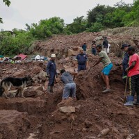 Des hommes aident les secouristes à mener leurs recherches après des inondations en Afrique du Sud.