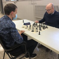 Deux hommes jouent aux échecs.
