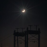 Une éclipse annulaire partielle du Soleil au-dessus d'un pont.