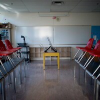 Une classe vide, les chaises levées sur les bureaux.