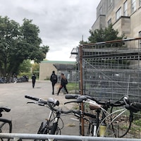 Des vélos stationnés près de clôtures amovibles à l'extérieur de l'école Sophie-Barat.