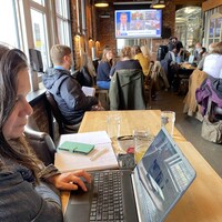 Une femme qui regarde son ordinateur dans un restaurant. 