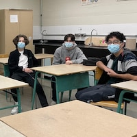 Des élèves assis dans une salle de classe. 