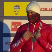 Éliot Grondin reçoit sa médaille de bronze sur le podium. 