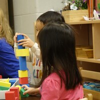 Trois enfants jouent avec des blocs.