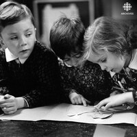 Trois enfants côte à côte manipulent des pièces pour un bricolage.