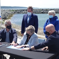 Le grand chef Jacques Tremblay signe une entente avec Caroline Rondeau et Ian Lafrenière devant le port de Gros-Cacouna.