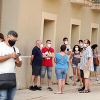 Des citoyens font la file pour le test de la COVID-19 près de Barcelone, en Espagne.