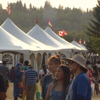 Des dizaines de visiteurs sont debout près de grandes tentes pour le Festival du patrimoine.