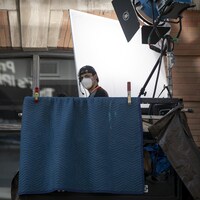 Un membre d'une équipe de tournage installé sous un projecteur à Toronto.