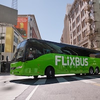 Un autocar FlixBus tourne à la gauche dans une intersection d'une ville.