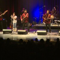 Les huit musiciens du groupe de musique Ninan sur scène.