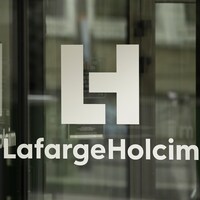 La porte principale du siège sociale de LafargeHocim est vitrée avec un lettrage blanc au nom de l'entreprise.