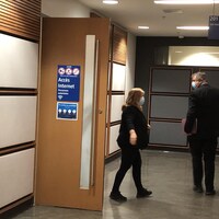 Une femme et un homme dans le couloir du palais de justice.