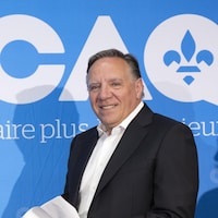 François Legault devant une affiche de la Coalition avenir Québec.