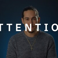 Gabriel Thibert regarde la caméra. Le mot ATTENTION est superposé sur l'image.