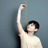 Un jeune garçon mesure sa taille.