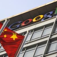 Un drapeau chinois flotte devant un bâtiment au logo de Google. 