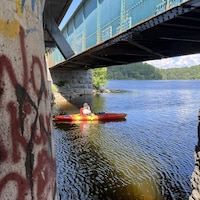 Un homme dans l'eau près des graffitis.
