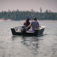Des pêcheurs assis dans une chaloupe.