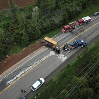 Vue aérienne d'un accident montrant un camion-benne renversé sur la chaussée.