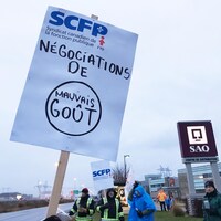 Pancarte avec le slogan « Négociations de mauvais goût » tenue par un gréviste.