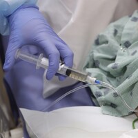 Une infirmière injecte un médicament par intraveineuse.