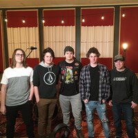 Les cinq jeunes musiciens côte à côte en studio