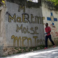 Un homme passe devant un graffiti près de la résidence où le président Jovenel Moïse a été assassiné à Port-au-Prince.