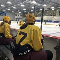 Deux joueuses de hockey assises dans les gradins du Complexe Sportif Thibault GM, à Sherbrooke. 