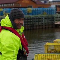 Un homme debout devant des casiers de pêche