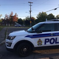 Une voiture de police d'Ottawa devant une scène de crime.