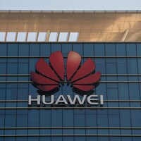 Gros plan sur le logo de Huawei sur la façade d'un gratte-ciel vitré.