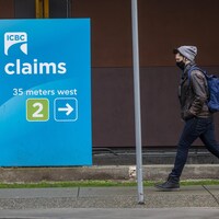 Une personne marche devant un centre de réclamation de ICBC à Vancouver. 