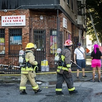 Des pompiers marchent dans le quartier du Downtown Eastside. 