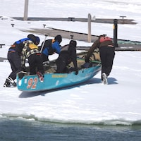 La canot vient de quitter l'eau et commence à être poussé sur la glace.