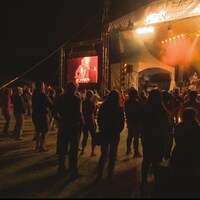 Un public debout assiste à un spectacle.
