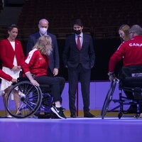 Plusieurs ministres autour de personnes de l'équipe du Canada en fauteuil roulant faisant une démonstration de curling