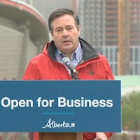 Jason Kenney en conférence de presse, à Calgary, devant le Saddledome.