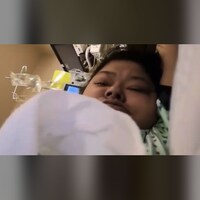 Une femme dans un lit d'hôpital.