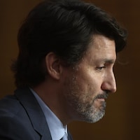 Justin Trudeau assis et de profil.
