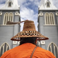Un membre de la Nation Squamish, en Colombie-Britannique, vue de dos devant une église.