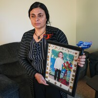Kamo Zandinan, dans son salon, tient dans ses mains une photo de sa fille disparue.