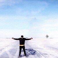 Kaya Free, les bras ouverts dans une prairie recouverte de neige.