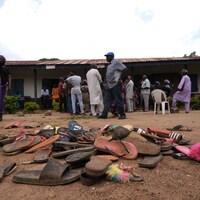 Des sandales empilées devant une école.