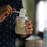 Une personne mesure une préparation lactée hypoallergénique destinée à un nourrisson.