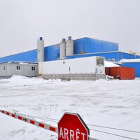 Vue extérieure des bâtiments de la mine Nyrstar Langlois, avec une barrière d'arrêt