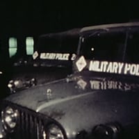 Deux voitures de type jeep avec l'inscription "military police" sur leur pare-brise. 