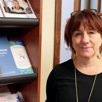 Une femme sourit pour la caméra.